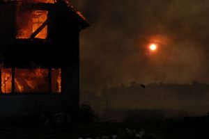 house on fire at night, rural location