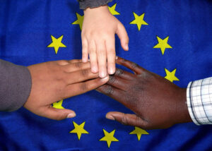 white black and brown hands on EU flag
